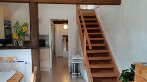 A spacious kitchen with a wooden staircase leading to an upper level. - Dream vacation apartment on an idyllic farm near Eltz Castle (Münstermaifeld)