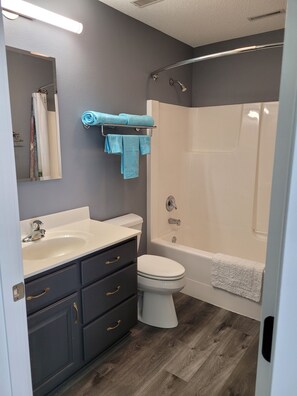 Een moderne badkamer met een wastafel, toilet en douche.