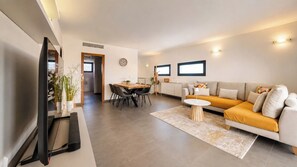 Un salon moderne avec un canapé, une table basse et un coin repas.