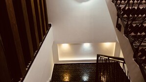 A staircase with a black metal railing and a patterned floor. - Manzilisurfhouse (Tamraght)