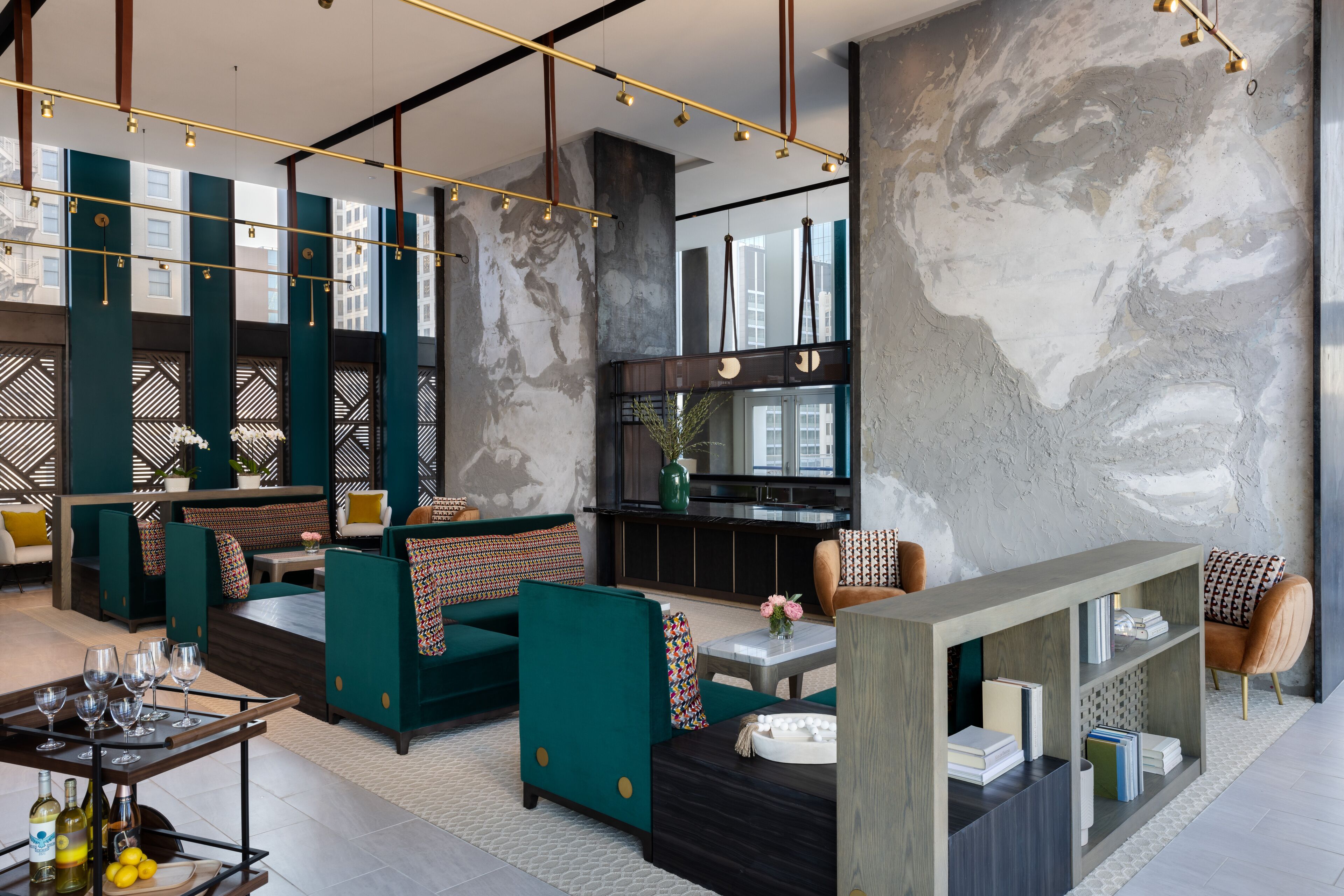 A modern lounge area with seating, a bar, and a bookshelf.