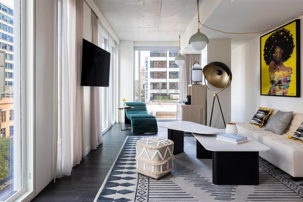 A modern living room with a sofa, coffee table, and a large painting.