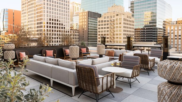 A rooftop lounge with seating and tables, surrounded by city buildings. - Hyatt Centric Congress Ave Austin (Austin)