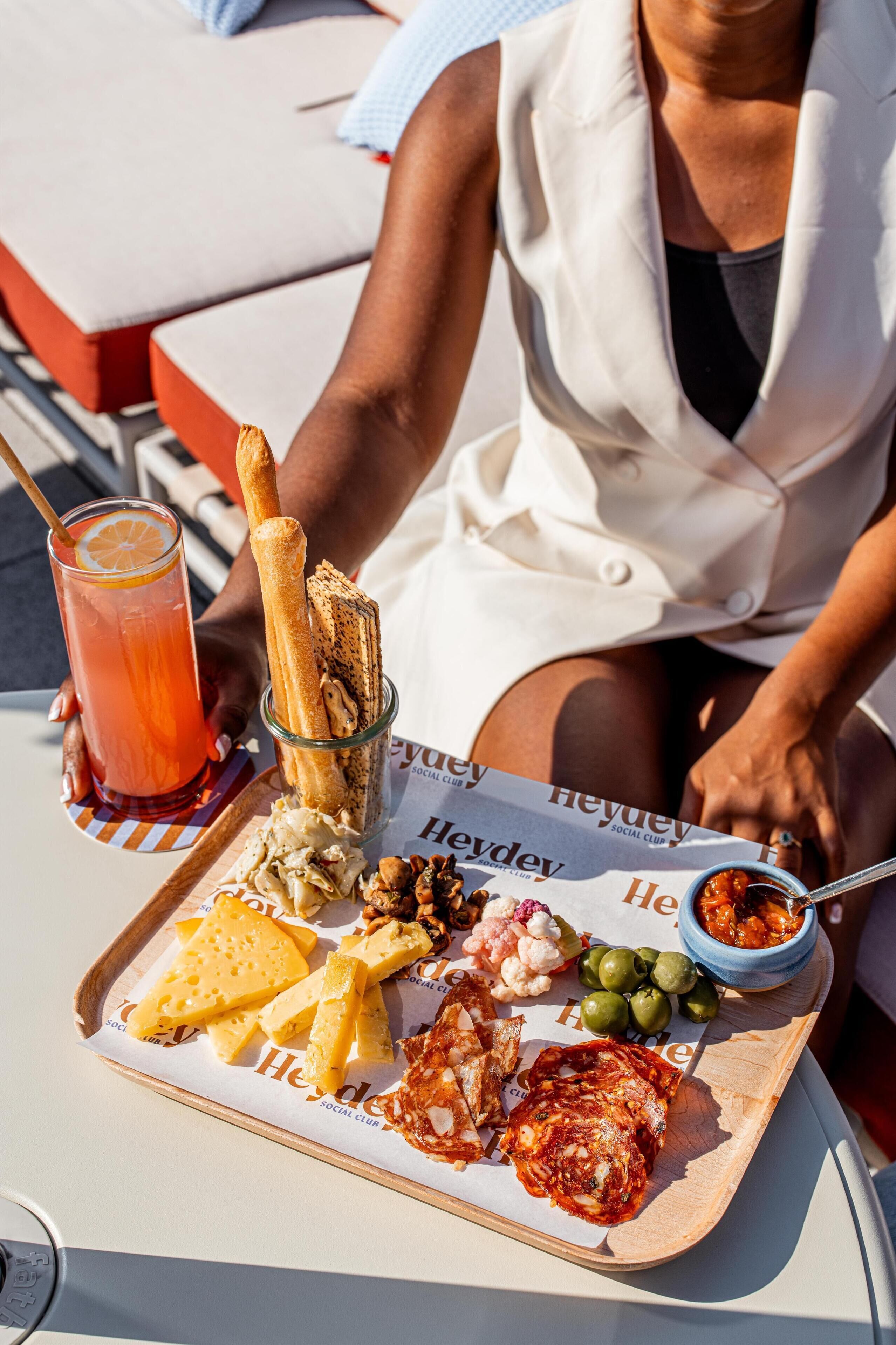A tray with various foods including cheese, bread, and olives.