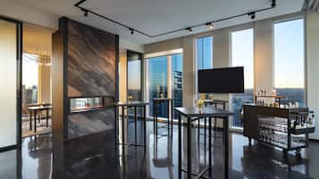 A modern bar area with high ceilings, large windows, and a city view.