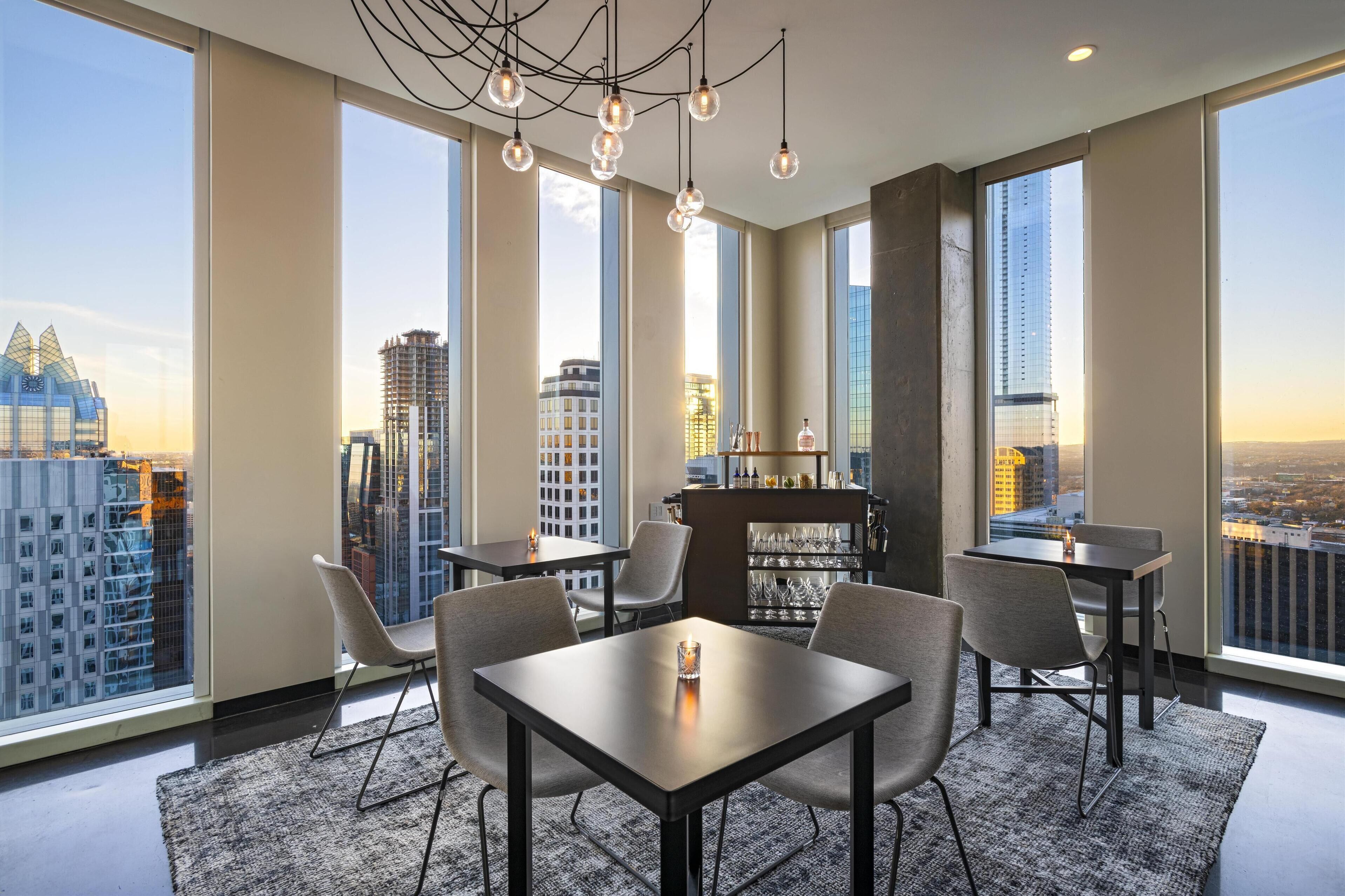 Un comedor moderno con barra, ventanas amplias y vista a la ciudad.