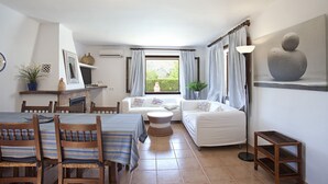 A cozy living room with a fireplace, a dining area with striped tablecloths, and a large window with curtains. - Ideal for families with pool, Can Seguinot (Pollensa / Pollença)