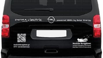 La parte trasera de un vehículo eléctrico negro con un logotipo de energía solar y un código QR.