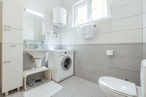 Tina con regadera, secadora de cabello, bidet, toallas 