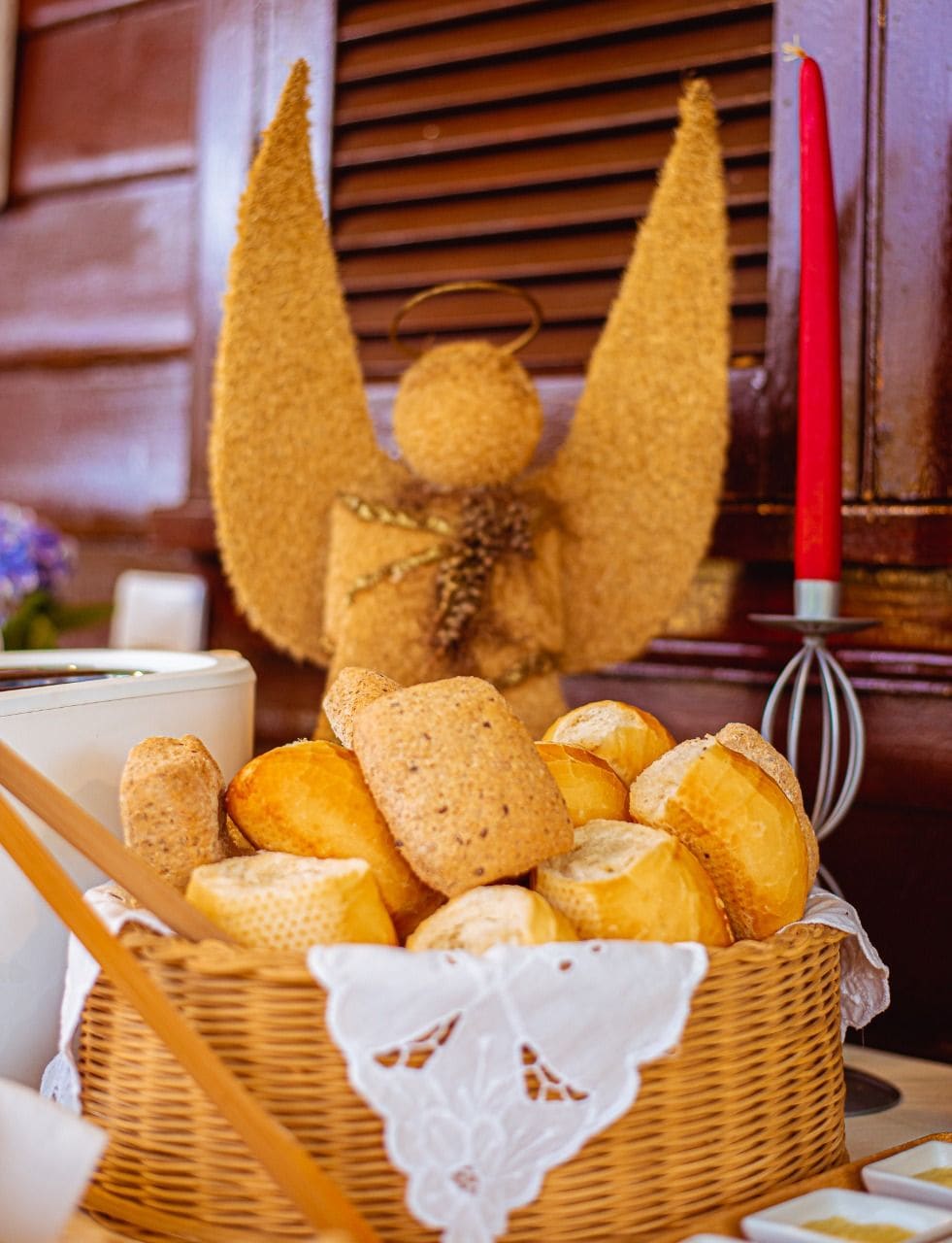 A basket of bread and a candle on a table.