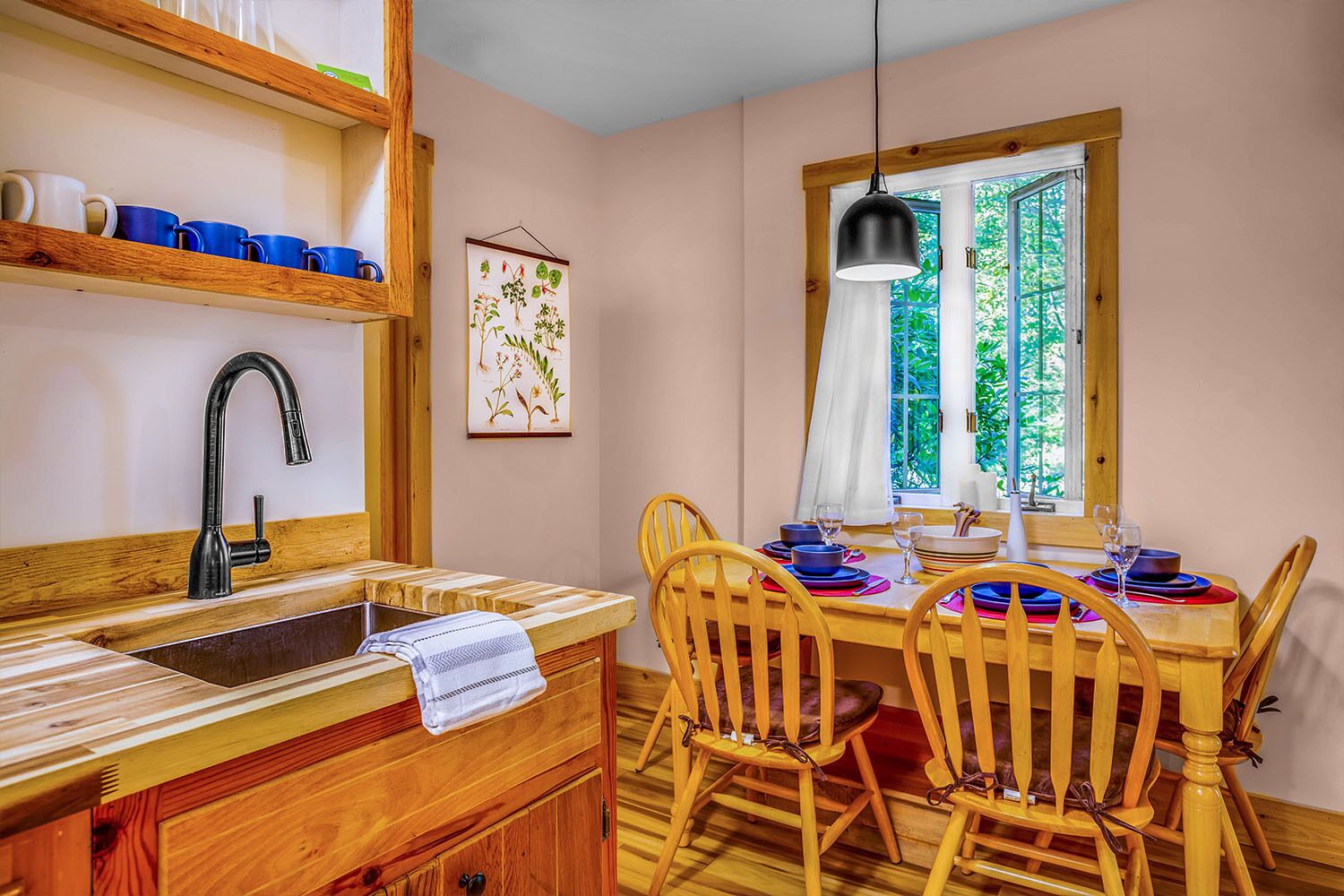 A kitchen with wooden cabinets, a black faucet, and a dining table set with chairs.