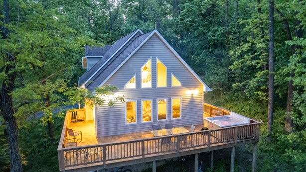 A two-story house with a deck, large windows, and a garage.