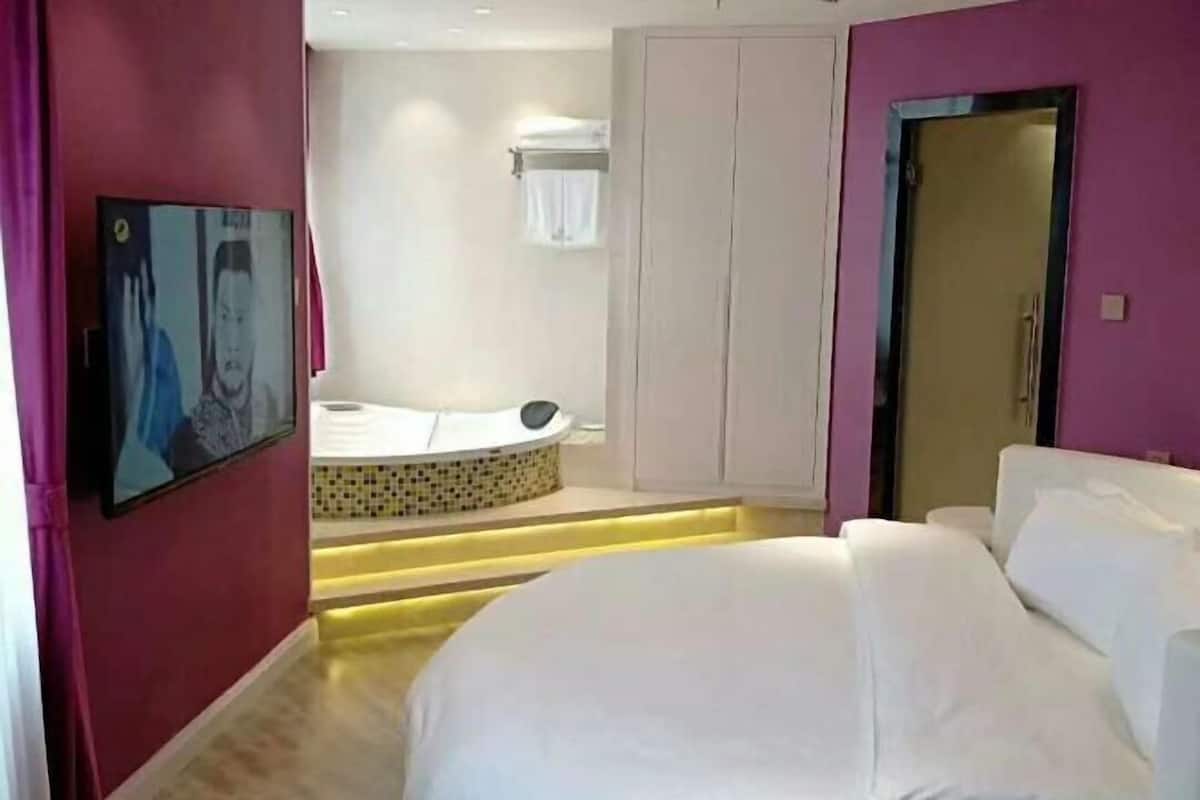 Una habitación de hotel con cama, bañera y armario.