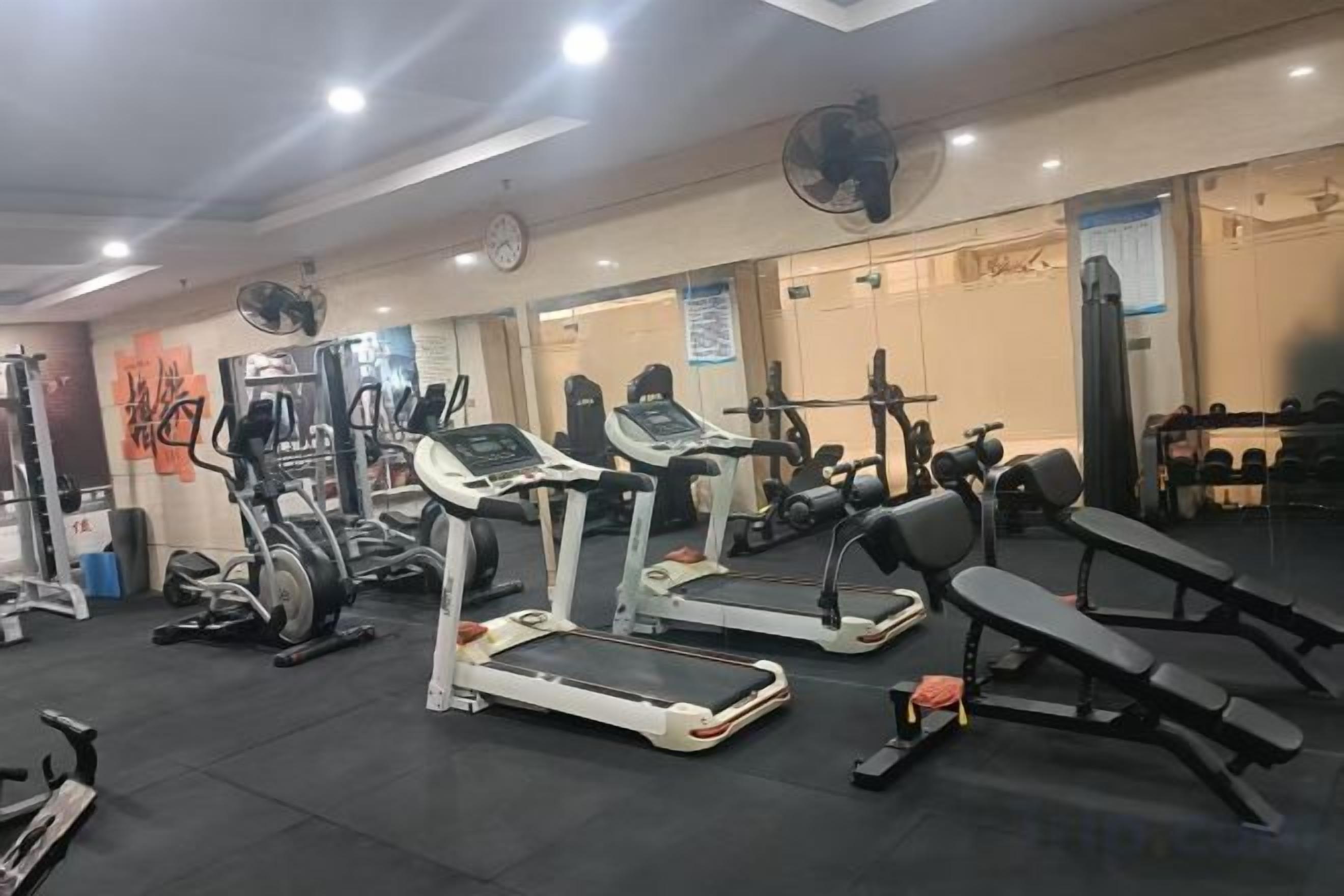 A gym with treadmills, weight machines, and benches.