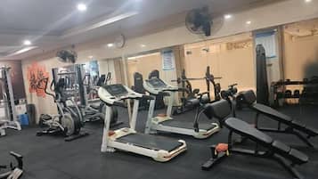 A gym with treadmills, weight machines, and benches.