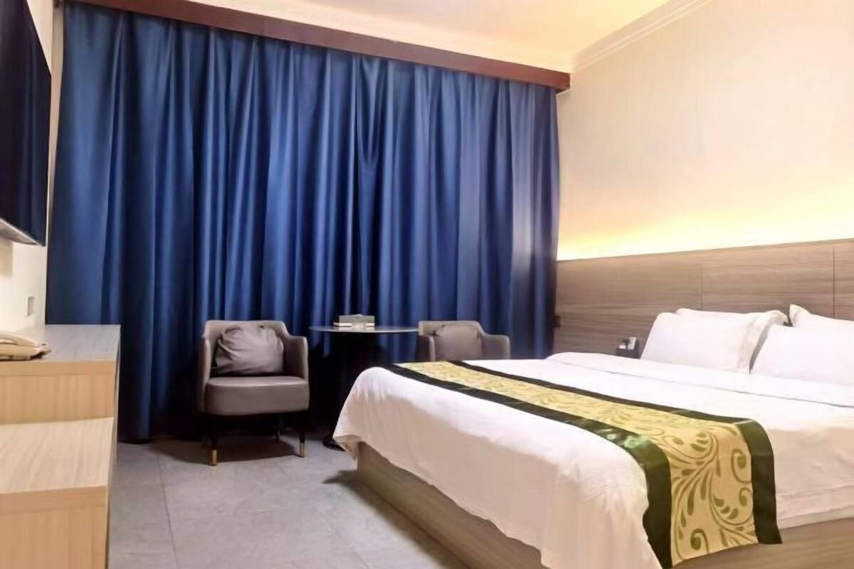 Una habitación de hotel con cama, escritorio, silla y una mesita.