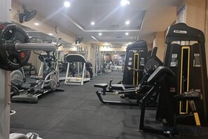 A gym with various exercise equipment including weight machines, treadmills, and free weights. - Yizhang Yiyuan Hotel (Yizhang)