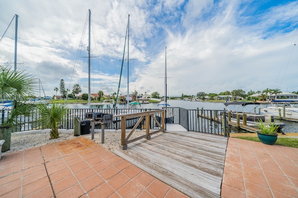 Un port de plaisance avec des bateaux amarrés, une terrasse en bois et une vue sur l’eau.