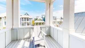Un balcon fermé offrant une vue sur les maisons voisines.