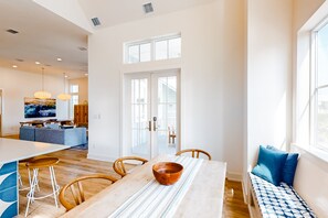Relax in this spacious room with a large dining table, bench, and comfortable seating areas.
