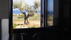 Una cocina con vista a un árbol y montañas.
