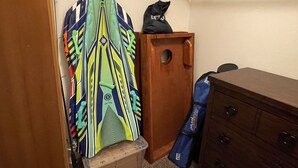 A room with a wooden wardrobe, a desk, and a colorful sports jersey hanging on a door. - Cozy Cascade Cabin. Relaxing Hot Tub, Secluded, Spacious and Creek Nearby (Rhododendron)