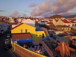 A residential area with colorful houses and a hilly landscape in the background.