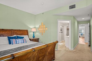 Quarto com cama de madeira, mesa de cabeceira com abajur e luminária na parede.