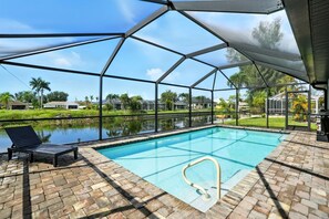 Una piscina cubierta al aire libre con vistas despejadas del paisaje circundante, que incluye casas y vegetación.