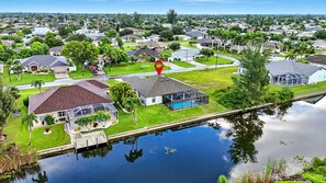 Zona residencial con casas, piscina y muelle sobre un cuerpo de agua.