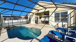Ein überdachter Außenpool mit Basketballkorb, ein Essbereich mit Tisch und Stühlen sowie eine überdachte Terrasse.