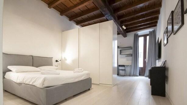 Ein Schlafzimmer mit Bett, Kleiderschrank, Schreibtisch und Stuhl.