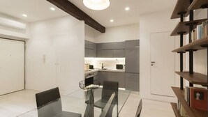 Ein modernes Interieur mit Essbereich, Küche und Bücherregal.