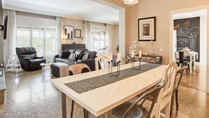 A spacious living room with a dining area, large windows, and a chandelier. - VILLA IN FUENGIROLA CENTER. NEW LUXURY POOL! (Fuengirola)