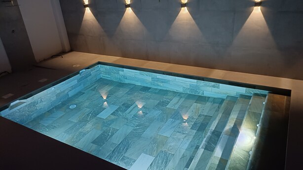 A rectangular indoor pool with a tiled floor and wall-mounted lighting fixtures. - VILLA IN FUENGIROLA CENTER. NEW LUXURY POOL! (Fuengirola)