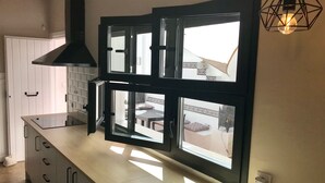 A modern kitchen with a large window, a black range hood, and a pendant light. - VILLA IN FUENGIROLA CENTER. NEW LUXURY POOL! (Fuengirola)