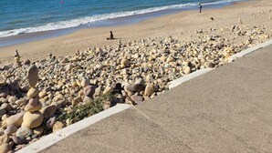 Ein Strand mit Kieselsteinen und blauem Himmel.