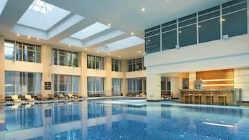 Une grande piscine intérieure dotée de plusieurs niveaux de gradins et d’un espace d’accueil.