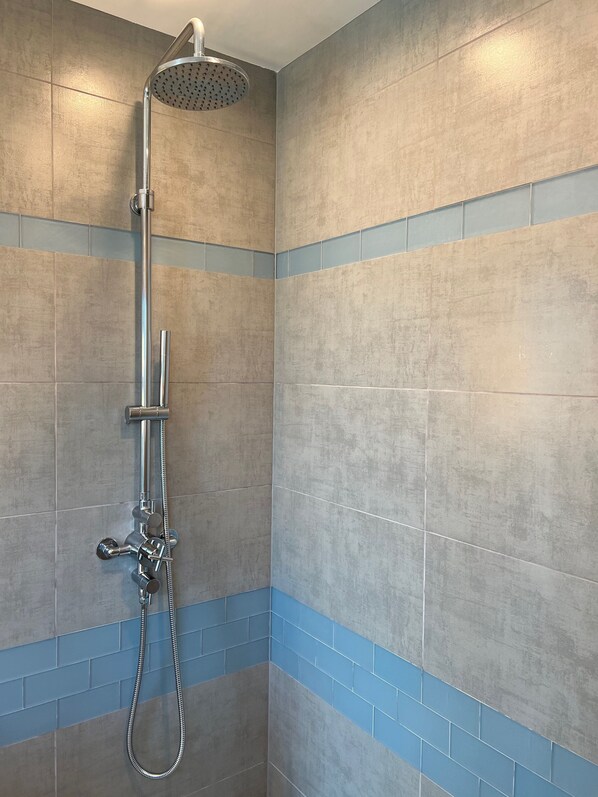 A shower with a handheld showerhead and a wall-mounted faucet. - "Cape Cod Beach-House" Panoramic Ocean View w/Hot Tub-5 min to Beach (Laguna Beach)