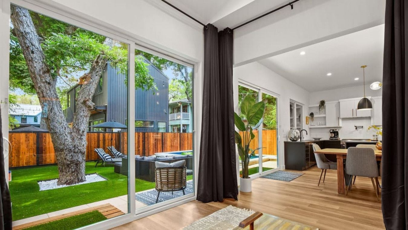 A spacious living area with large sliding glass doors leading to a backyard.