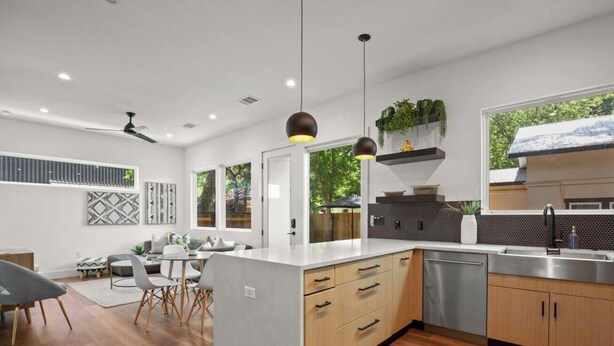 A modern kitchen with a central island, stainless steel appliances, and a view of the outdoors. - Holly #B xxxxxxxxxxx (Austin)