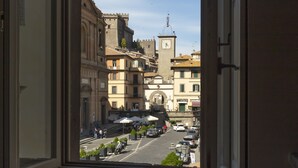 Vista desde una ventana de un edificio que muestra una calle con edificios y coches aparcados.