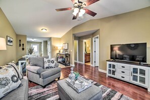 A living room with a grey sofa, ottoman, and a TV on a cabinet. - Quaint Family Home Near Downtown Murray & MSU (Murray)