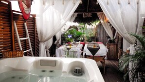Un espace spa comprenant un jacuzzi, des meubles en bois et un panneau décoratif avec le mot « LOVE ».