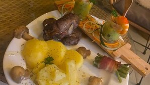 Une assiette de nourriture comprenant de la viande, des pommes de terre, des champignons et une boisson.