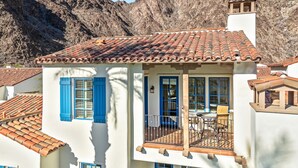 A two-story building with a tiled roof, blue shutters, and a balcony with outdoor furniture. - "The Palm Pad"🌴Newly Renovated Poolside Luxury 2-Story Townhome - (L44) (La Quinta)