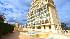 Un hôtel à plusieurs étages doté d’une piscine, de balcons et d’une architecture de style méditerranéen.