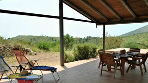 An outdoor patio with a covered area, a table set for dining, and chairs. - Cosy apartment for 6 people with WIFI, pool, TV, patio and pets allowed (Sperlonga)