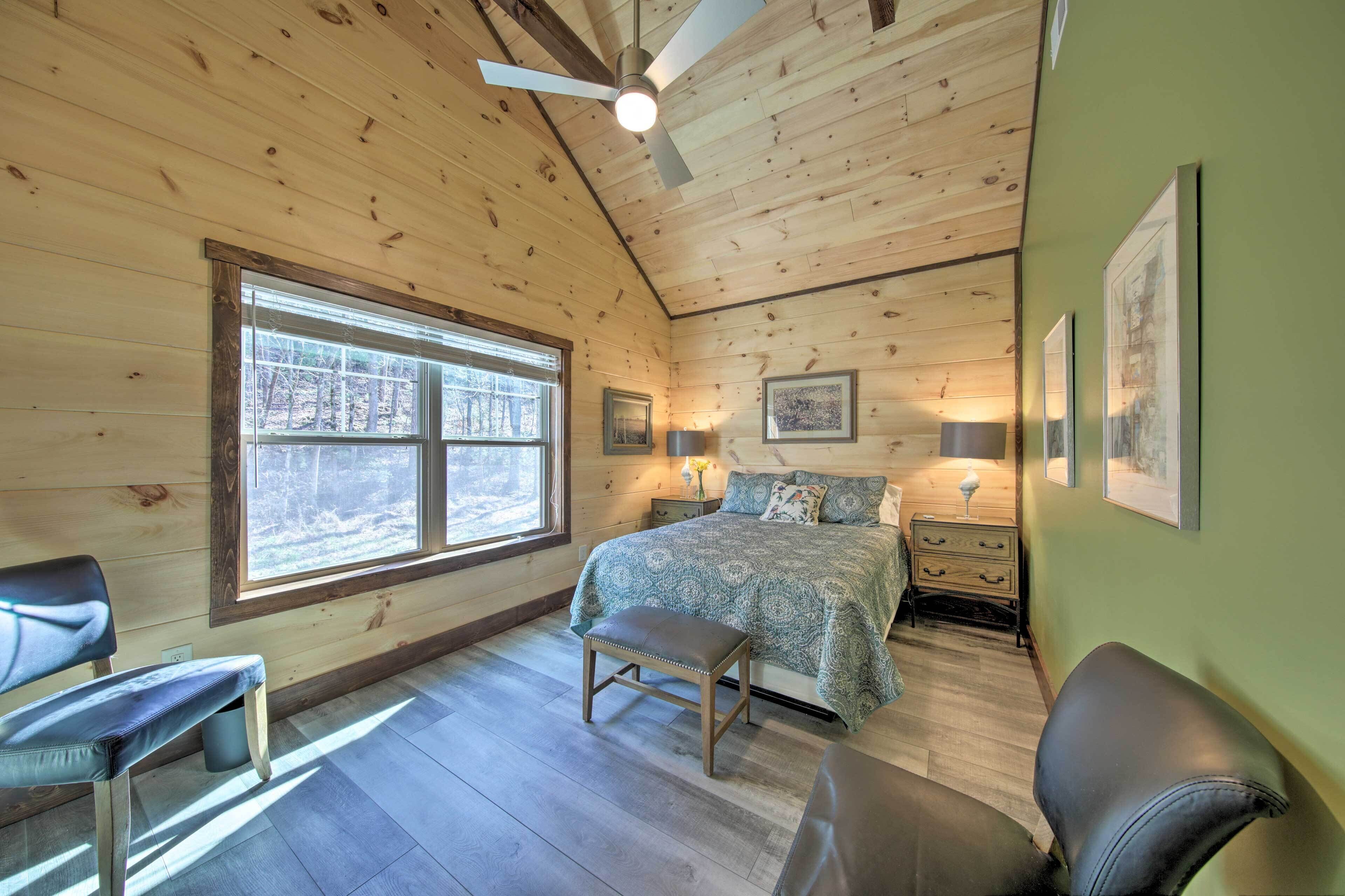 A wooden cabin bedroom with a bed, two nightstands, a bench, and a window.
