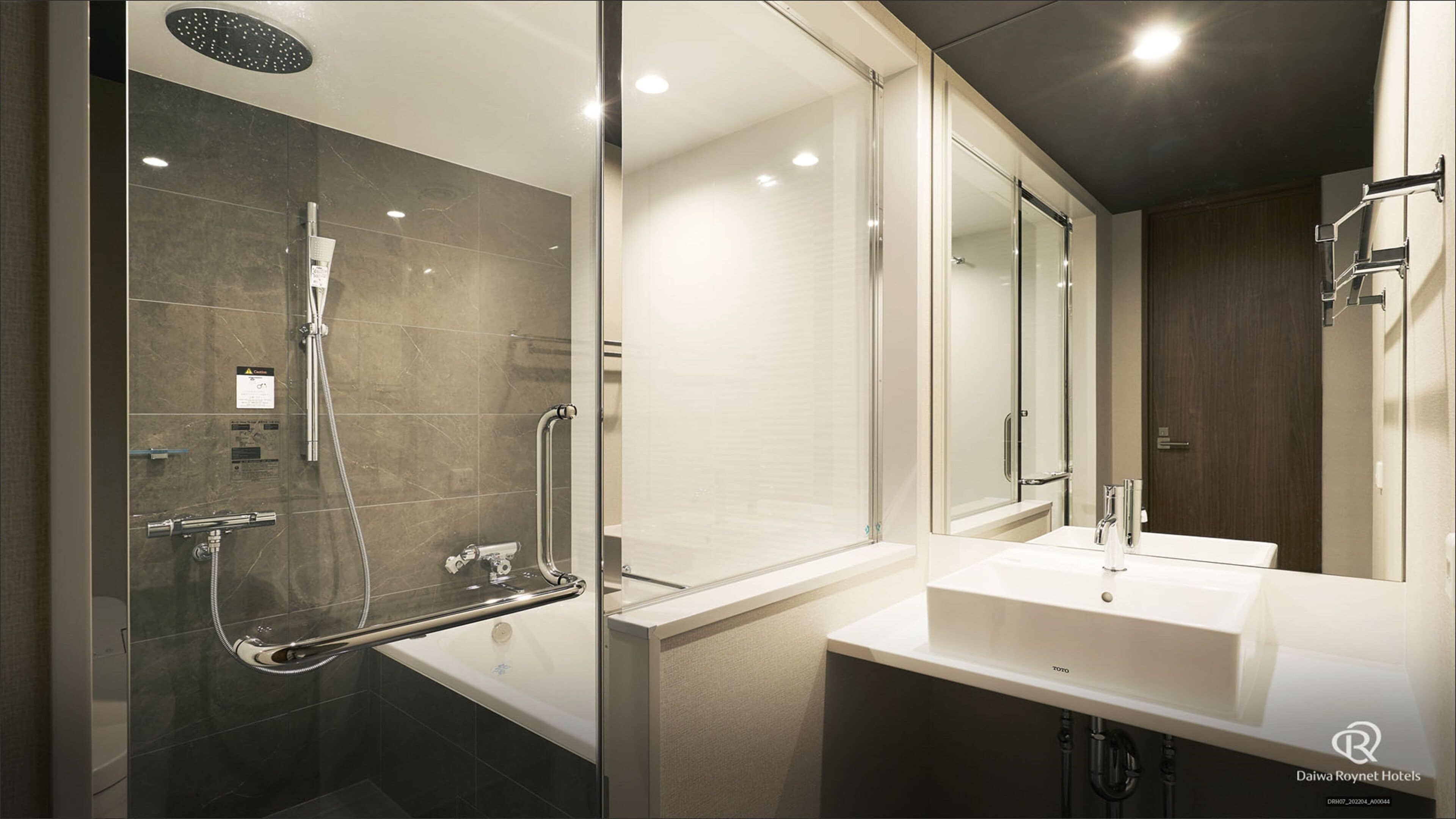 Un baño moderno con cabina de ducha de vidrio, bañera y tocador con espejo.